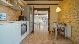 a kitchen with white cabinets and a table with a chair at Vila Luna in Comarnic