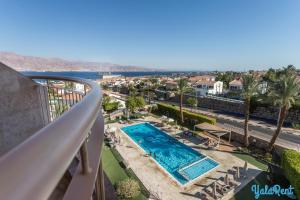 a balcony with a view of a pool and a street at YalaRent Amdar Lux in Eilat