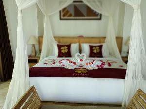 a bed with a white bedspread and pillows at The Kalyana Ubud Resort in Ubud