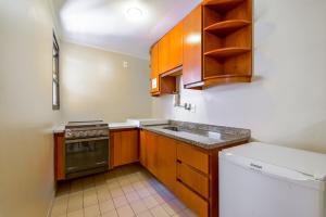 a small kitchen with a sink and a stove at Capital O Park Tower, Campinas in Campinas