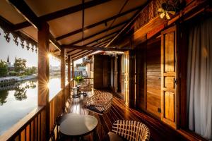 a balcony with chairs and tables on a boat at Punyashthiti villa in Chanthaburi