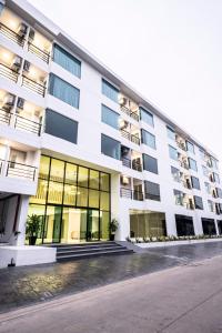 un gran edificio blanco con grandes ventanas en The Airport Courtyard Suvarnabhumi Airport en Bangkok