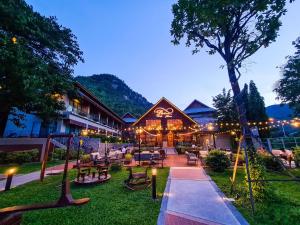 a resort with a playground and a building with lights at Plakan Resort in Kanchanaburi