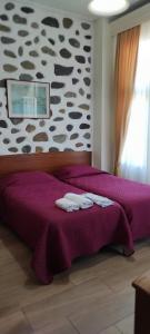 a room with a bed, a desk, and a painting on the wall at Porto Lesvos hotel in Mytilene