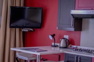 uma cozinha com um balcão com uma televisão na parede em 314 on Clark Guest House em Pretoria