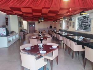 un restaurant avec des tables et des chaises et un auvent rouge dans l'établissement Le Roi Jammu - Near Jammu Railway Station, à Jammu