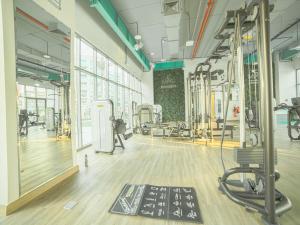 a gym with treadmills and machines in a room at OYO 617 Home 610, Mag 555 in Dubai