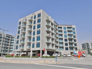 a tall white building with cars parked in front of it at OYO 617 Home 610, Mag 555 in Dubai