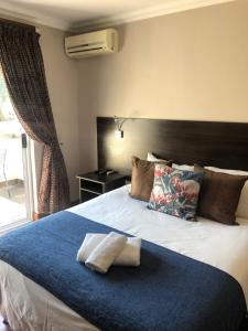 1 dormitorio con 1 cama grande y 2 almohadas en 314 on Clark Guest House, en Pretoria