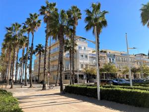 a large building with palm trees in front of it at Hotel Miramar Valencia in Valencia