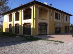 een groot geel gebouw met veel ramen bij Antico Noce in Granarolo dellʼEmilia
