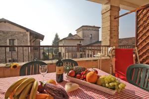 un tavolo con un cesto di frutta e una bottiglia di vino di Il Colombaro a Salò