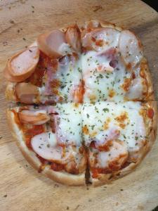 a pizza with shrimp and cheese on a wooden table at Chiangmai HomeTeL in Chiang Mai