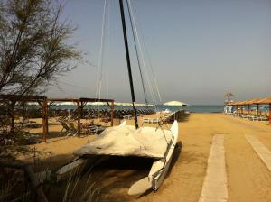 a boat sitting on the beach next to the ocean at Camping Pineta in Calambrone