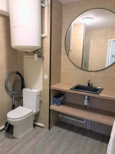 bagno con servizi igienici, lavandino e specchio di Bel appartement design tout confort (Parking Gratuit) à 10 minutes de Bordeaux a Cenon