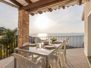 una mesa blanca y sillas en un balcón con vistas al océano en Holiday Home Joan Sarda by Interhome, en Roses