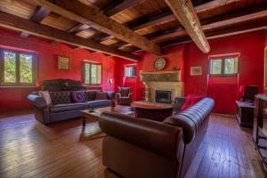 a living room with red walls and couches and a fireplace at Mulino dei Camini in Monteciccardo