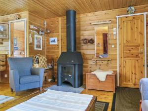 ein Wohnzimmer mit einem Holzofen in einer Hütte in der Unterkunft Holiday Home Huuhkalinna by Interhome in Syöte