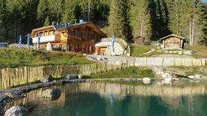 a log cabin with a lake in front of it at Ferienwohnung Sarah in Steeg