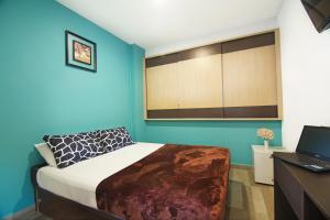 a bedroom with a bed and a desk with a laptop at Tai Hoe Hotel in Singapore