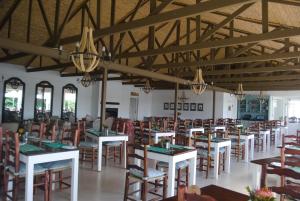 una sala da pranzo con tavoli e sedie in un edificio di De Hoop Collection - Vlei Cottages a De Hoop Nature Reserve Altre 11 foto