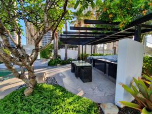 an outdoor patio with a table and a tree at High-End Apartment in the Soul of Surfers Paradise in Gold Coast