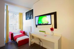a room with a desk and a tv on the wall at INA Boutique 072 Hamburg St Georg in Hamburg
