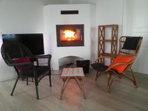 a living room with chairs and a fire in a fireplace at Fjordvejen Apartments in Gråsten