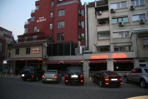 un groupe de voitures garées devant un bâtiment dans l'établissement Hotel Bordo, à Plovdiv