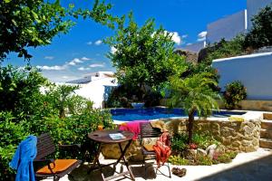 a patio with a table and chairs next to a pool at La Vista de Medina Studios & Apartments in Medina Sidonia