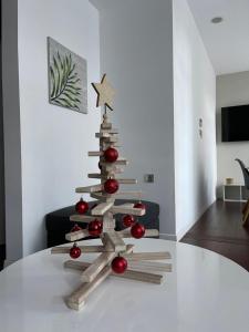 a wooden christmas tree on a table in a living room at Beau T4 Hyper Centre avec Parking in Perpignan