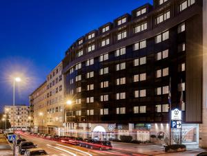 duży budynek na ulicy miejskiej w nocy w obiekcie Hotel Giberti & Spa w Weronie