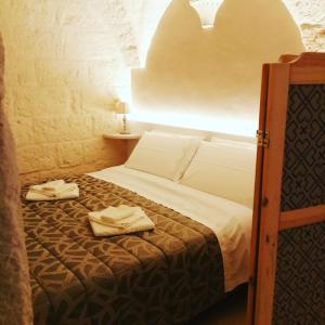 a bedroom with a bed with two towels on it at Al Caveau - Holiday House in Fasano