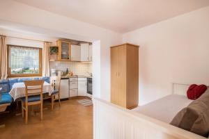 a room with a bed and a kitchen with a table at Haus Belodei - Apt A in San Martino in Badia