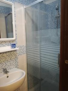 a bathroom with a glass shower and a sink at B&B PompeiLog in Pompei