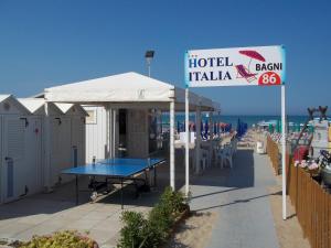 a hotel tavern with a table and a sign on the beach at Hotel Italia in Senigallia