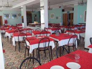 una sala da pranzo con tavoli e sedie rossi di Hotel Italia a Senigallia