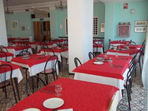 a dining room with red tables and chairs at Hotel Italia in Senigallia