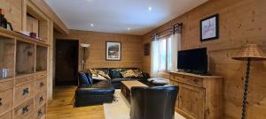 a living room with a leather couch and a tv at Chalet Brimborion in Champéry