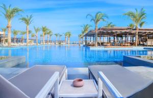 a swimming pool with palm trees and a resort at IBEROTEL Costa Mares in Marsa Alam City