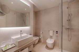 een badkamer met een wastafel, een toilet en een douche bij NH Palermo in Palermo