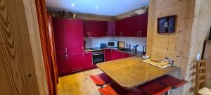 a kitchen with red cabinets and a table and chairs at Chalet Brimborion in Champéry
