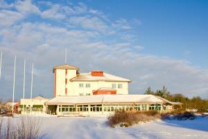een groot wit gebouw in de sneeuw voor de deur bij Hotel Kalkstrand in Pargas