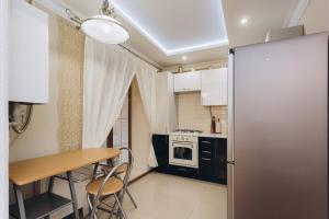 uma pequena cozinha com uma mesa e um frigorífico em Luxury Apartment em Sumy