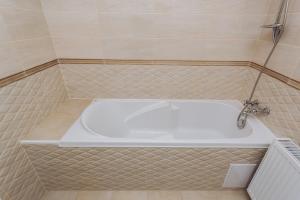 uma banheira numa casa de banho em azulejo com um lavatório em Luxury Apartment em Sumy