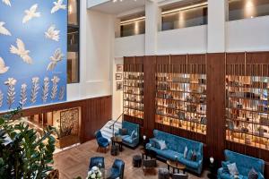a library with blue couches and books at Electra Metropolis in Athens