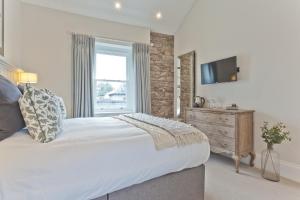 a bedroom with a large bed and a television at Tithe Barn - Self Check In Hotel in Cockermouth