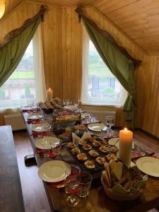 una mesa larga con comida y velas en una habitación en Dacha en Yasinya