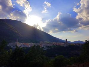 a view of a city with the sun setting on a mountain at Chalet Vacanze Il Daino in Leonessa +18 photos