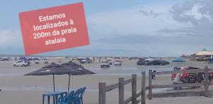 un cartello su una spiaggia con sedie e ombrellone di Pousada Aconchego a Salinópolis